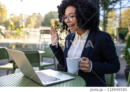 Business woman sitting in a cafe and having a video call 118949580