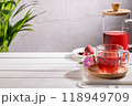 Red fruit infusion in crystal glass and pitcher on wooden base with copy space. 118949709