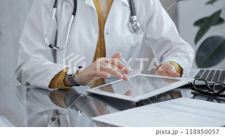 Doctor woman using tablet on the glass desk in medical office. Medicine and health care 118950057
