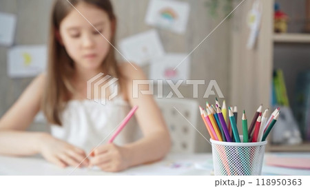 A close-up of colored pencils on the desk, with a creative young A close-up of colored pencils on the desk, with a creative young 118950363