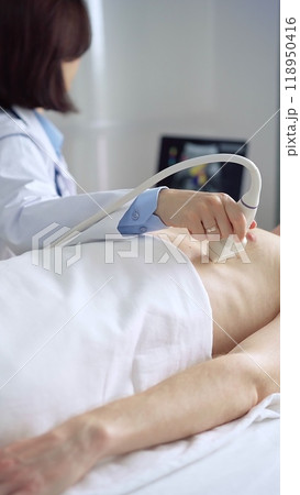 Female doctor using ultrasound machine examining patient abdomen and heart Female doctor using ultrasound machine examining patient abdomen and heart 118950416