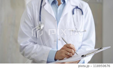 Female doctor filling medical form on clipboard, writing prescription, making notes. Medicine and science 118950676