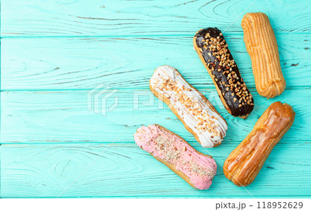 Assorted eclairs on a pastel top view Traditional French dessert 118952629