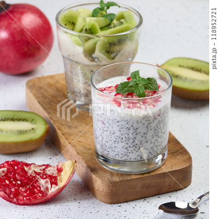 Two glasses of chia yogurt dessert garnished with fresh fruit, pomegranate seeds and kiwi slices Two glasses of chia yogurt dessert garnished with fresh fruit, pomegranate seeds and kiwi slices 118952721