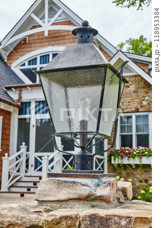 Elegant Outdoor Lantern on Stone Pillar with Modern Home Facade 118953384