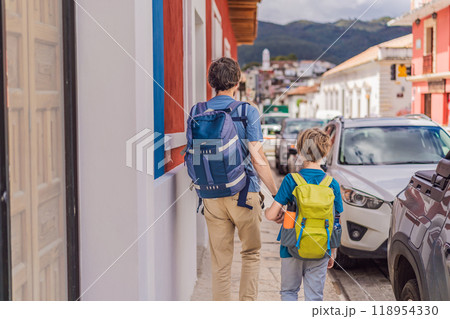 Father and and his two sons, a teenager and a baby tourists walks through the colonial streets San Cristobal de las Casas, Mexico. Cultural exploration, architecture, and travel experience concept 118954330