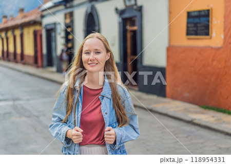 Female tourist walks through the colonial streets San Cristobal de las Casas, Mexico. Cultural exploration, architecture, and travel experience concept 118954331