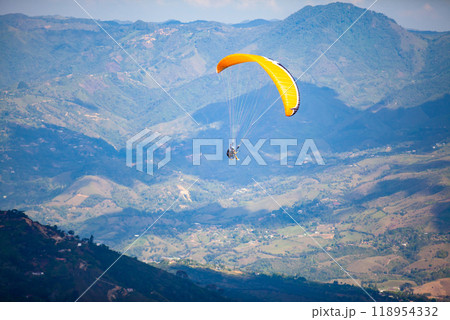 People paragliding over the beautiful mountains of the Antioquia department in Colombia. Tandem Paragliding. Extreme sport concept. 118954332
