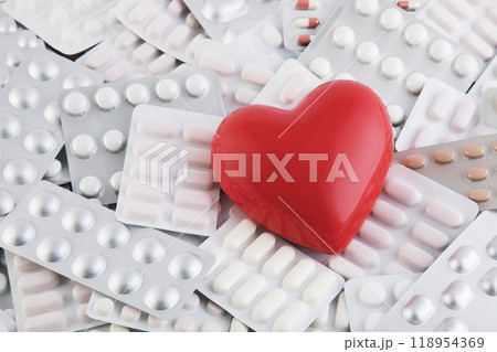 Red heart on big heap of many various pills and tablets packs 118954369