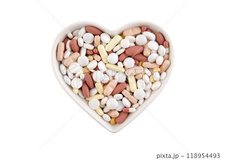 Plate in shape of heart with heap of medicine pills or dietary supplements isolated on white background Plate in shape of heart with heap of medicine pills or dietary supplements isolated on white background 118954493