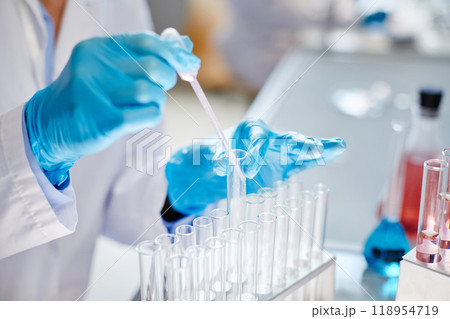 Close up on gloved hands of unrecognizable lab worker dripping liquid from dropper into test tube making reaction while developing new pharmaceuticals in laboratory, copy space Close up on gloved hands of unrecognizable lab worker dripping liquid from dropper into test tube making reaction while developing new pharmaceuticals in laboratory, copy space 118954719