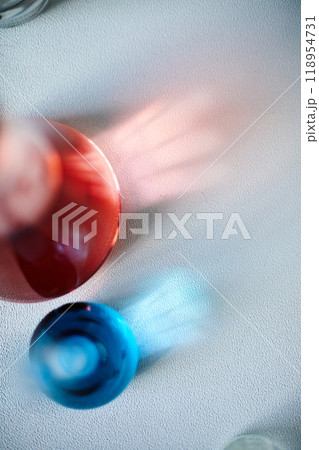 Top view of light reflection going through glass beakers filled with red and blue liquids placed on laboratory table, copy space Top view of light reflection going through glass beakers filled with red and blue liquids placed on laboratory table, copy space 118954731