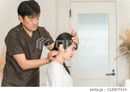 整体院・整骨院・マッサージに通う女性と整体師・セラピスト 118957414