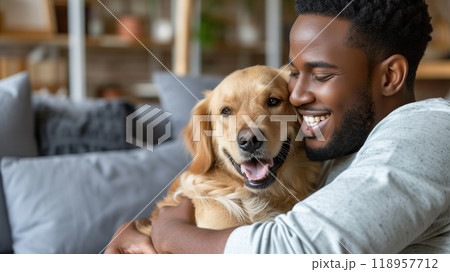 Smiling Man cuddling with His happy Golden Retriever indoor at Home. Smiling Man cuddling with His happy Golden Retriever indoor at Home. 118957712