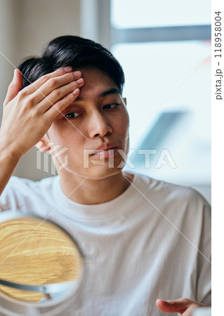肌をケアする20代の若い男性 肌をケアする20代の若い男性 118958004