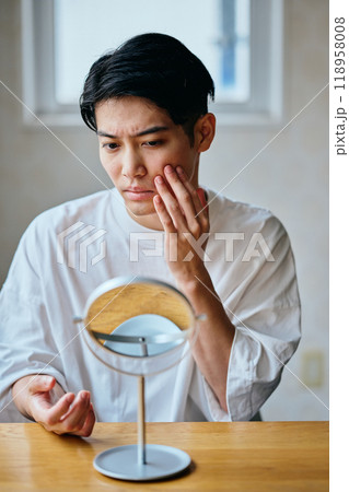 肌を気にする20代の若い男性 肌を気にする20代の若い男性 118958008