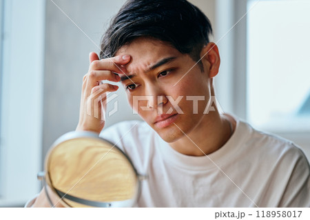 肌を気にする20代の若い男性 肌を気にする20代の若い男性 118958017