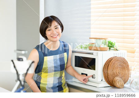 電子レンジの前で料理動画を収録する女性 電子レンジの前で料理動画を収録する女性 118959666