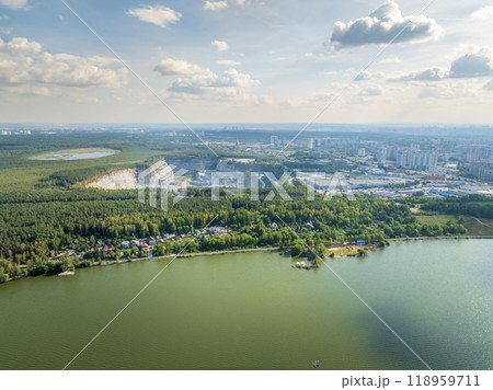 Stone quarry in the forest. Flying over the summer mixed forest during sunset. The surroundings of Yekaterinburg. Ural, Russia, Aerial View Stone quarry in the forest. Flying over the summer mixed forest during sunset. The surroundings of Yekaterinburg. Ural, Russia, Aerial View 118959711