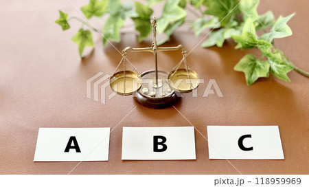 天秤と3枚のカードにABCの文字_茶色背景 118959969