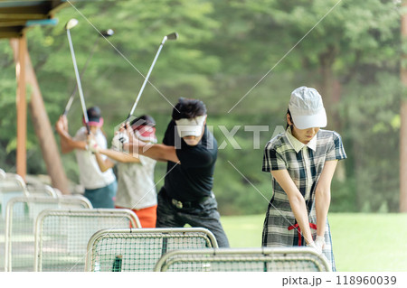 ゴルフ練習場・打ちっぱなし・ゴルフセンターでスイングの練習するゴルフ選手・ゴルファーの男女 118960039