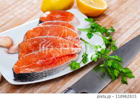 Raw salmon steaks with lemon, parsley, garlic Raw salmon steaks with lemon, parsley, garlic 118962815