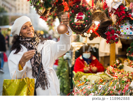 Woman are preparing for Christmas and choosing balls on tree 118962888