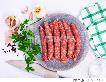 Traditional spanish dish. Longaniza, pork sausage on plate with herbs and cutlery 118962914