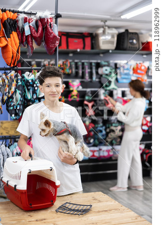 Teen boy choose carrier for small pet Yorkshire terrier dog Teen boy choose carrier for small pet Yorkshire terrier dog 118962999