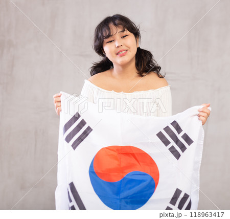 Smiling young girl holding South Korea flag 118963417