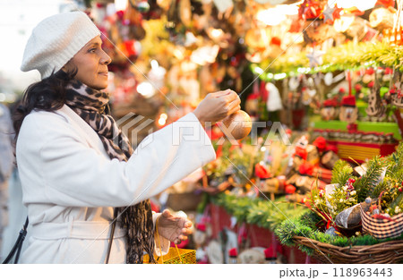 Latino woman with Christmas tree toy in her hand buys decorations for new year 118963443