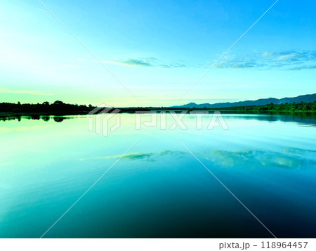a calm lake at dawn, reflecting the soft hues of the sky on its still surface, silhouette of distant hills and trees frames the horizon, water gently mirroring the serene landscape, sky transitions a calm lake at dawn, reflecting the soft hues of the sky on its still surface, silhouette of distant hills and trees frames the horizon, water gently mirroring the serene landscape, sky transitions 118964457