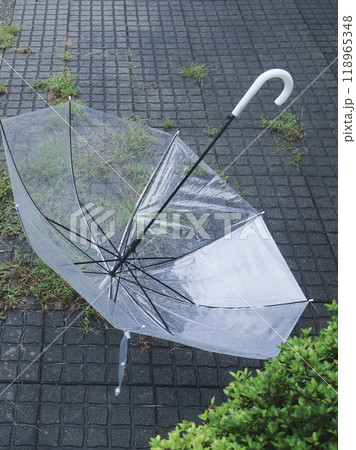 地面に転がった、雨粒の付いたビニール傘 118965348