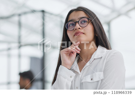 a girl stands in a modern office and looks at the camera a girl stands in a modern office and looks at the camera 118966339