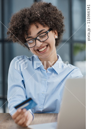 a girl in a modern office pays for purchases on the Internet using a credit card a girl in a modern office pays for purchases on the Internet using a credit card 118966341
