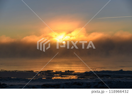 Beautiful sunset with fog in Arctic sea at winter time. Fog at sea. Frozen air. 118966432