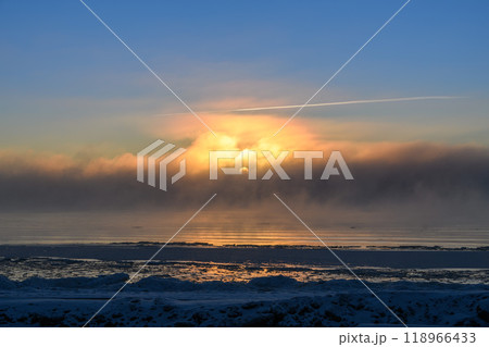 Beautiful sunset with fog in Arctic sea at winter time. Fog at sea. Frozen air. 118966433