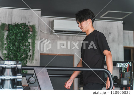 スポーツジムでトレッドミル・ランニングマシンを使ってウォーキング・有酸素運動をするアジア人男性 スポーツジムでトレッドミル・ランニングマシンを使ってウォーキング・有酸素運動をするアジア人男性 118966823