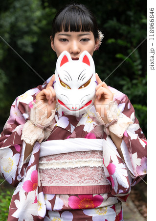 狐面を持ちポーズをとる着物の女性 118966846