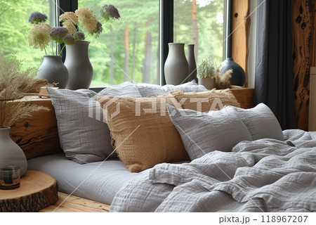 Cozy bedroom with a bed, pillows and vases near the window 118967207