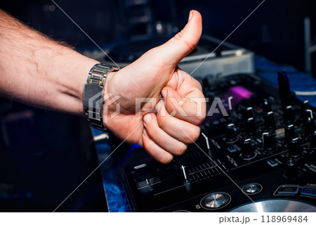 hand of DJ shows the class background of switchers and remote control in nightclub hand of DJ shows the class background of switchers and remote control in nightclub 118969484