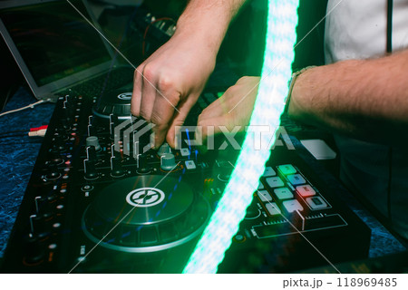 hands of the DJ booth playing music and mixer in nightclub 118969485