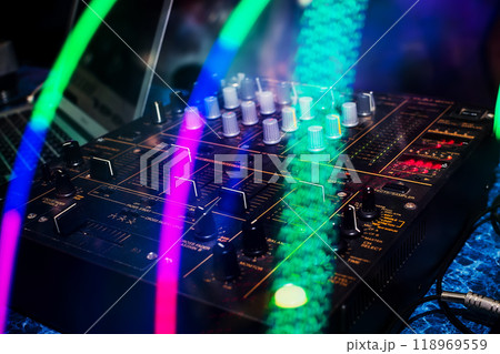 music mixer with knobs and volume levels for professional DJ mixing in night club 118969559