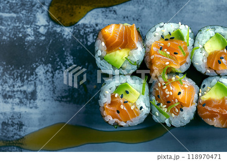 A set of fresh sushi rolls with salmon, avocado and black sesame seeds served on a plate A set of fresh sushi rolls with salmon, avocado and black sesame seeds served on a plate 118970471