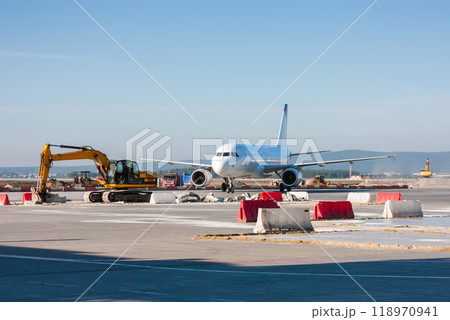 Passenger Aircraft maneuvering between excavators and bulldozers Passenger Aircraft maneuvering between excavators and bulldozers 118970941