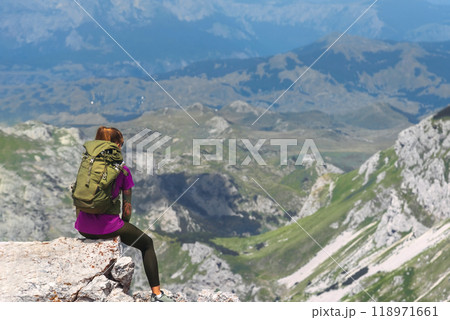 Woman Sitting on Mountain Summit Cliff after Climbing 118971661
