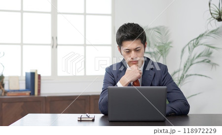 パソコンの前で悩むビジネスマン パソコンの前で悩むビジネスマン 118972229