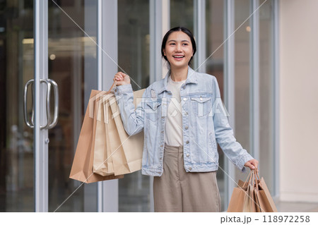 Young Shopper Experiencing Joy with Shopping Bags Outdoors Young Shopper Experiencing Joy with Shopping Bags Outdoors 118972258