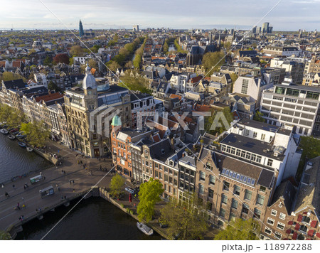 Historical Center of Amsterdam, Netherlands. Aerial Drone Shot of Traditional Dutch houses on narrow street and channel. 118972288