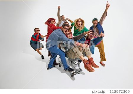 Group of emotional people, men in women pushing forward the best shopping deals, pushing shopping cart. Intensity of shopping activity Group of emotional people, men in women pushing forward the best shopping deals, pushing shopping cart. Intensity of shopping activity 118972309
